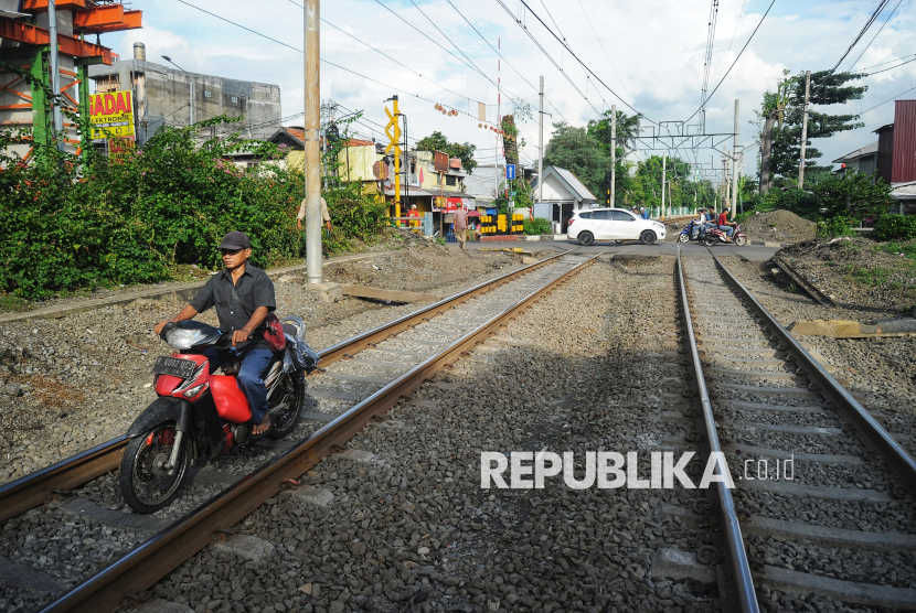 Pengendara sepeda motor nekat menyusuri rel melalui perlintasan liar di kawasan Pramuka, Jakarta Timur, Kamis (22/5/2025).