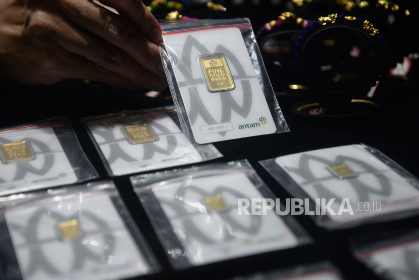 Penjual menunjukan emas batangan di toko emas Cikini, Jakarta, Rabu (22/7). 