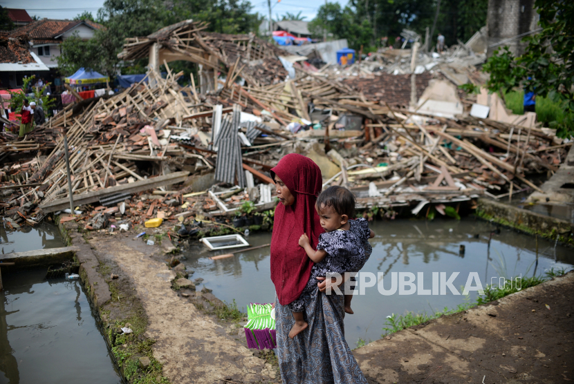 Pengungsi berjalan di depan bangunan yang roboh akibat gempa di Desa Gasol, Kecamatan Cugenang, Kabupaten Cianjur, Jawa Barat, (ilustrasi).