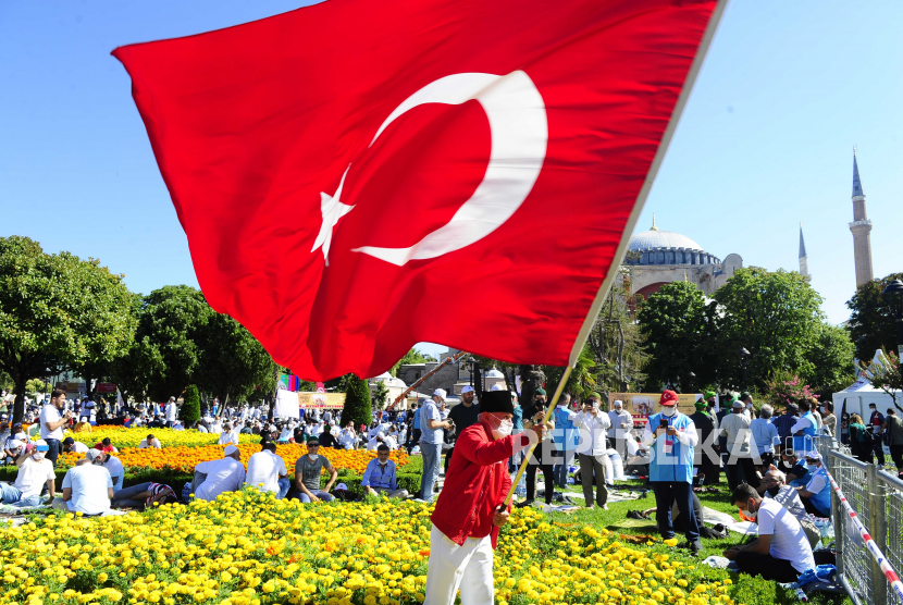 Peneliti Arab Saudi: Turki Jadikan Ideologi Islam Alibi. Foto ilustrasi: Seorang pria mengibarkan bendera Turki di luar Hagia Sophia era Byzantium, di distrik bersejarah Sultanahmet di Istanbul, Jumat, 24 Juli 2020. 