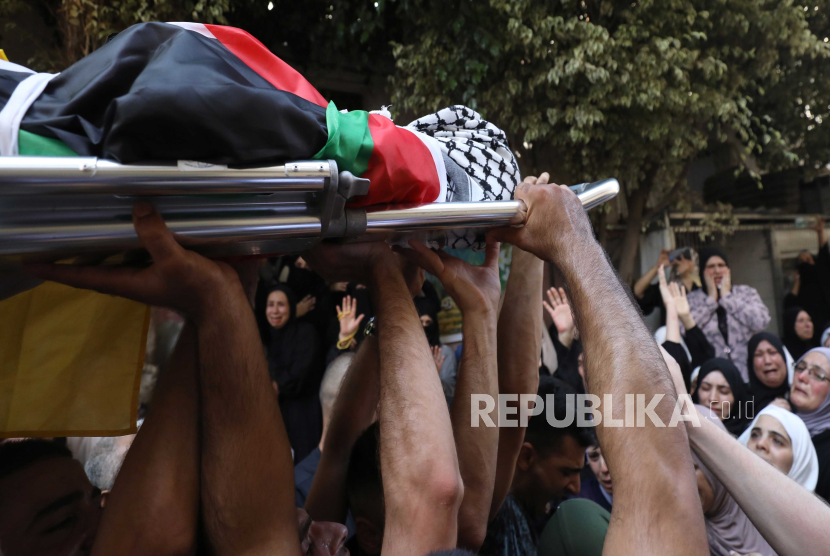 Warga Palestina membawa jenazah Fris Zaid yang berusia 14 tahun saat dilakukan pemakaman di kota Qalqilya, di Tepi Barat, Kamis (27/7/2023).   