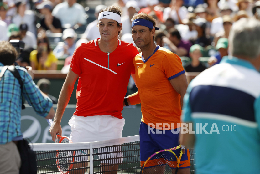 Taylor Fritz dari AS (kiri) dan Rafael Nadal dari Spanyol berpose bersama di depan net sebelum pertandingan final putra turnamen tenis BNP Paribas Open di Indian Wells Tennis Garden di Indian Wells, California, AS, Senin (21/3/2022). Turnamen berlangsung dari 07 hingga 20 Maret 2022.