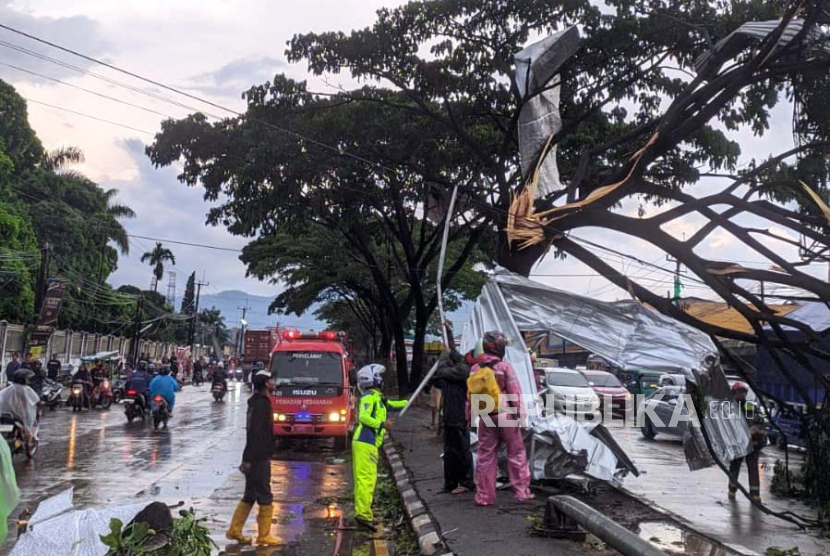 Petugas gabungan melakukan evakuasi material pohon tumbang dan material rumah yang terbawa puting beliung di Jalan Raya Bandung-Garut, Rancaekek, Kabupaten Bandung, Rabu (21/2/2024). 