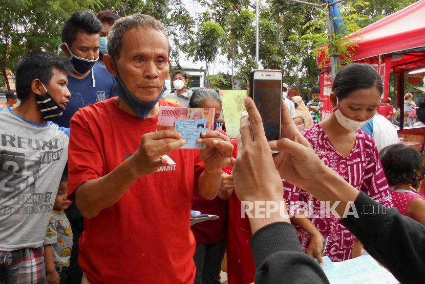 Warga menunjukkan uang bantuan saat penyaluran Bantuan Sosial Tunai (BST) (ilustrasi). BST di Tangerang Selatan, Banten mulai sudah mulai dibagikan dan ditargetkan rampung pada Jumat (15/1).