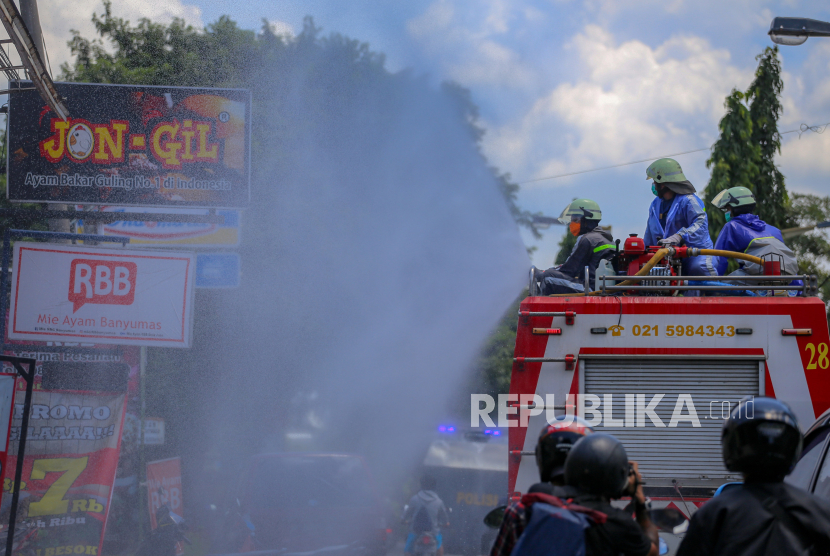 Petugas pemadam kebakaran menyemprotkan cairan disinfektan di Regency, Kabupaten Tangerang, Banten, Selasa (31/3/2020). Penyemprotan cairan disinfektan tersebut dilakukan serentak di 15 titik di Kabupaten Tangerang guna mencegah penyebaran COVID-19