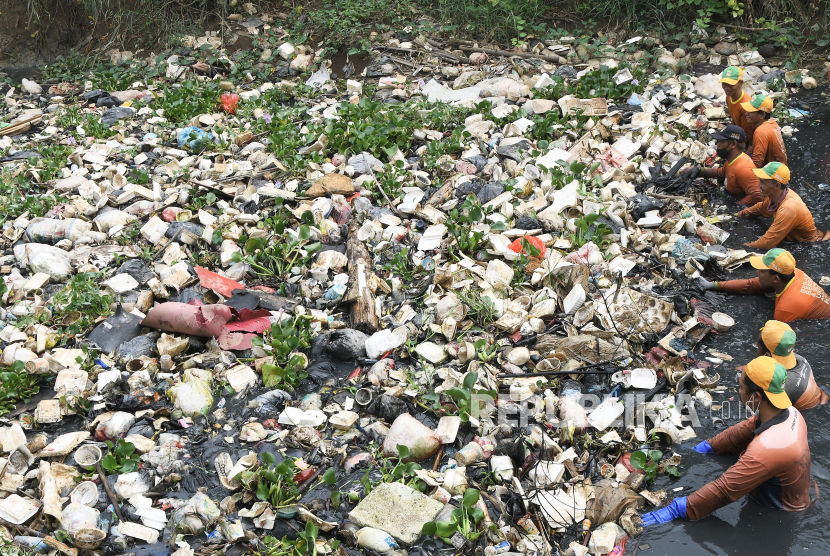 Sejumlah petugas Dinas Lingkungan Hidup mendorong sampah untuk diangkat menggunakan alat berat eskavator di aliran Kali Cikarang, di Sukaringin, Kabupaten Bekasi. Menurut petugas, sebanyak 15 truk disiapkan untuk mengangkut sampah yang menumpuk dan dibawa ke TPA Burangkeng. 