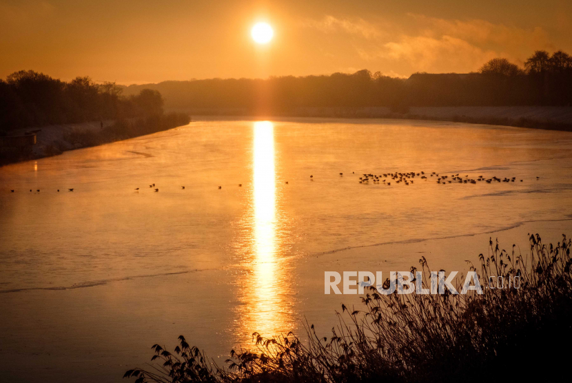 Pagi Hari, Waktu yang Didoakan Nabi Muhammad. Foto:  Burung-burung duduk di atas es danau Werdersee saat matahari terbit di pagi es di Bremen, Jerman utara, Ahad (31/1/2021). Sebagian besar barat laut Jerman tertutup salju.