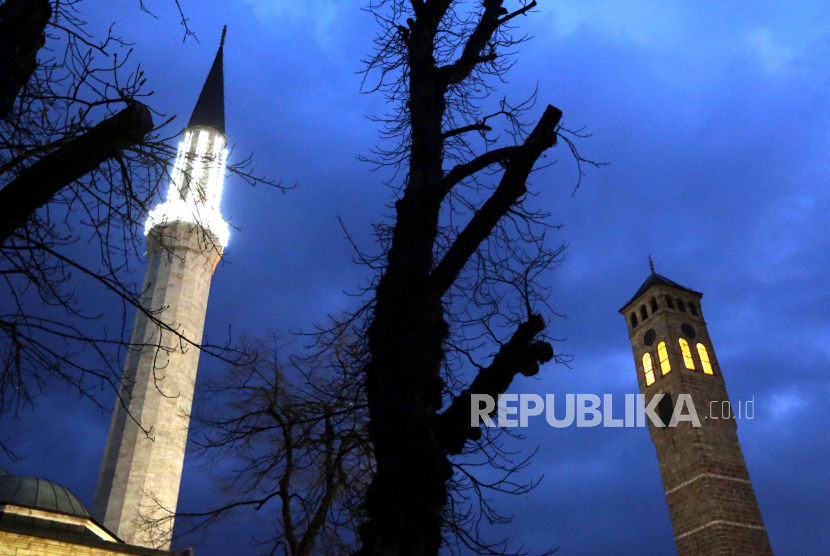  Pemandangan umum menunjukkan menara Masjid Gazi Husrev-beg (kiri) dan menara jam (kanan), saat malam Ramadhan di Sarajevo, Bosnia dan Herzegovina,  Senin (10/4/2023).