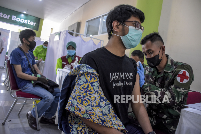 Vaksinator menyuntikan vaksin Covid-19 ke warga saat pelaksanaan vaksinasi Covid-19 dosis ketiga (booster) secara massal di Vaccine Center Booster Sport Jabar Arcamanik, Jalan Pacuan Kuda, Kota Bandung. 