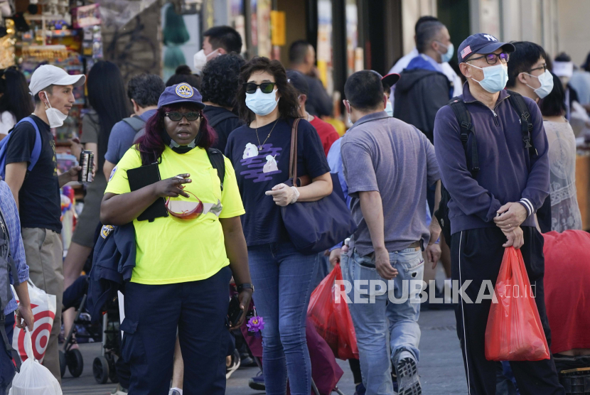 Pejalan kaki mengenakan masker pelindung selama pandemi virus korona pada hari Rabu, 19 Mei 2021, di wilayah Queens, New York. 