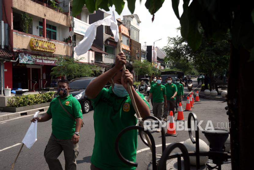Satpol PP D.I Yogyakarta mencopot bendera putih yang dipasang Pedagang Kaki Lima (PKL) Malioboro usai aksi 