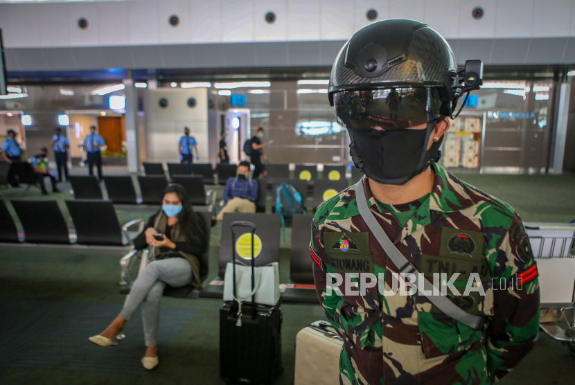 Personel TNI menggunakan helm pendeteksi suhu tubuh di Terminal 3 Bandara Internasional Soekarno Hatta, Tangerang, Banten, Sabtu (23/5/2020). Helm thermal KC wearable tersebut digunakan sebagai alat pendeteksi suhu tubuh hingga jarak 10 meter