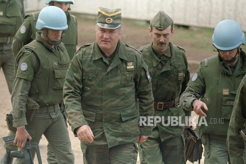 Ini adalah file foto 12 April 1993 dari tentara Serbia Bosnia Jenderal Ratko Mladic, kedua dari kiri, ditemani oleh seorang ajudan, dan pasukan keamanan PBB Prancis tiba di pertemuan yang disponsori PBB di bandara Sarajevo. 
