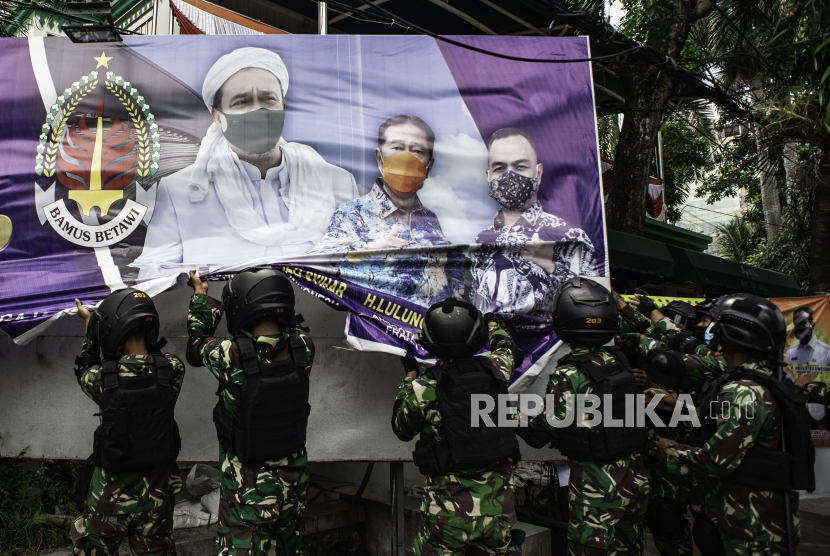 Prajurit TNI menertibkan spanduk tidak berizin saat patroli keamanan di Petamburan, Jakarta, Jumat (20/11/2020). Sebanyak 500 personel gabungan dari TNI dikerahkan untuk menertibkan spanduk ataupun baliho yang tidak memiliki izin di wilayah yang berada di bawah pengamanan Kodam Jaya/Jayakarta. 