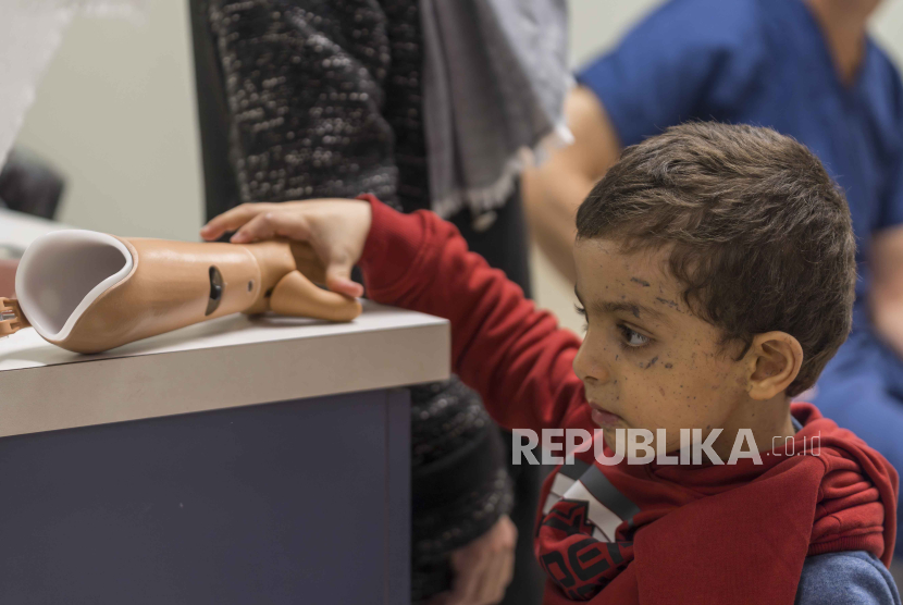 Omar Abu Kuwaik yang berusia empat tahun memeriksa lengan palsu barunya di Shriners Children. 