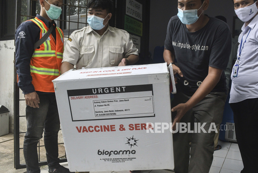 Pekerja membawa sekotak vaksin COVID-19 untuk disimpan di gudang di Bekasi, Jawa Barat, Indonesia, Selasa, 12 Januari 2021. Otoritas Makanan dan Obat-obatan Indonesia telah memberikan lampu hijau untuk penggunaan darurat vaksin COVID-19 yang diproduksi oleh Sinovac Biotech Ltd. yang berbasis di China, dengan vaksinasi kelompok berisiko tinggi diharapkan dimulai akhir pekan ini.
