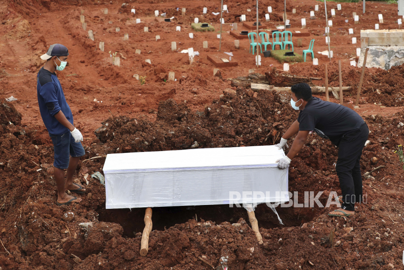 Pekerja menyiapkan peti mati untuk dimakamkan di bagian khusus pemakaman Jombang yang dibuka untuk menampung lonjakan kematian saat wabah virus Corona, di Tangerang, Indonesia, Selasa 26 Januari 2021. Indonesia telah melaporkan lebih banyak kasus virus daripada yang lain. negara di Asia Tenggara.