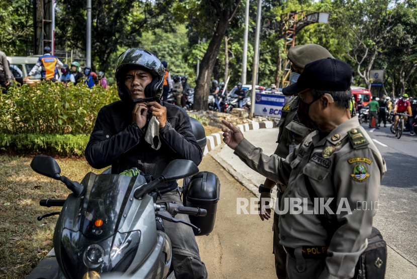 Sejumlah petugas gabungan saat menindak warga yang tidak menggunakan masker. Sebanyak 69 pelanggar tertib masker, di tengah masa pandemi COVID-19, terjaring aparat Tiga Pilar di Kecamatan Tambora, Jakarta Barat, Senin pagi.