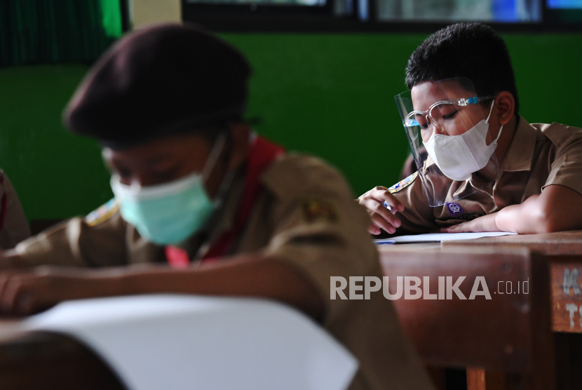 Sejumlah murid mengerjakan soal Penilaian Akhir Tahun (PAT) saat menjalani uji coba pembelajaran tatap muka (PTM) tahap 2 di SDN Kebayoran Lama Selatan 17 Pagi, Jakarta, Rabu (9/6/2021). 