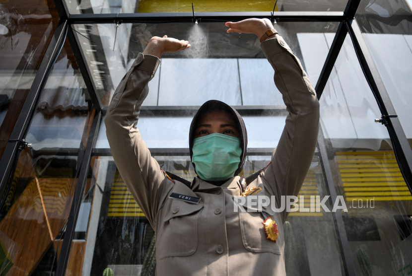 Seorang Polwan berada di dalam bilik disinfektan di Polda Metro Jaya, Jakarta, Selasa (24/3/2020). Bilik tersebut disediakan di pintu masuk yang wajib dilewati pengunjung untuk mencegah penyebaran virus corona (covid-19)