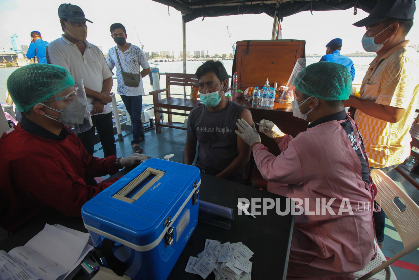 Petugas kesehatan menyuntikkan vaksin COVID-19 kepada warga saat Vaksinasi Merdeka di atas kapal patroli Polairud Polda Jawa Timur di perairan Lumpur, Gresik, Jawa Timur, Selasa (3/8/2021). Direktorat Kepolisian Perairan dan Udara Polda Jawa Timur menggelar vaksinasi COVID-19 dengan sasaran nelayan dan masyarakat pesisir guna mewujudkan kekebalan kelompok atau 