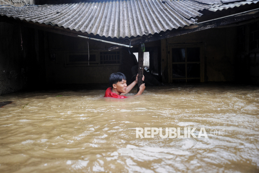 Warga melintasi banjir yang merendam kawasan Perumahan Sawangan Asri, Depok, Jawa Barat, Selasa (4/3/2025). Banjir dengan tinggi air mencapai 1,5 meter tersebut disebabkan luapan Kali Pesanggrahan yang melintas di belakang perumahan.  Menurut warga air mulai menggenangi sejak Senin pukul 22.00 WIB. Banjir di perumahan tersebut merendam sekitar 40 rumah warga.