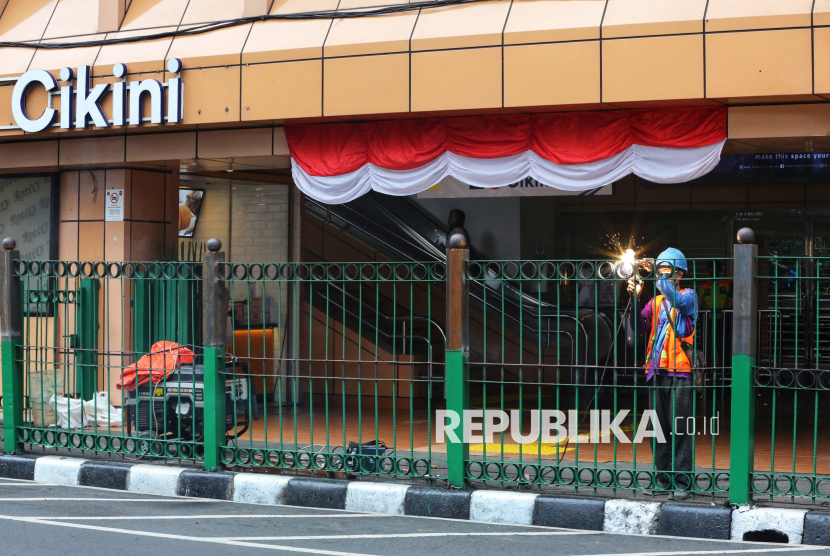 Pekerja menyelesaikan proyek peninggian pagar di Stasiun Cikini, Jakarta, Selasa (12/8/2025). PT Kereta Api Indonesia Daerah Operasi 1 Jakarta (Daop 1) bersama PT Kereta Commuter Indonesia (KCI) melakukan penertiban akses keluar-masuk penumpang dengan meninggikan pagar pedestrian sepanjang sekitar 240 meter dengan ketinggian menjadi 1,7 meter, guna mencegah penumpang kereta rel listrik (KRL) melompati pagar yang membahayakan keselamatan. Berdasarkan pantauan, pengerjaan pagar masih berlangsung dan baru sebagian selesai. Sementara pagar setinggi satu meter yang belum ditinggikan masih menjadi celah bagi warga untuk melanggar, meski telah terpasang spanduk larangan. Sejumlah penumpang KRL mengaku enggan memutar lewat jalur resmi karena dianggap terlalu jauh, demi menghemat waktu dan tenaga.