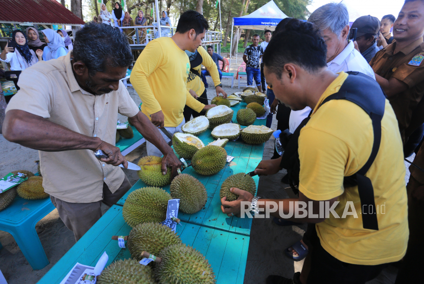 Petugas membuka buah durian saat festival dan lomba durian. Pemkab Muara Enim menggelar festival durian untuk mempromosikan wisata alam.