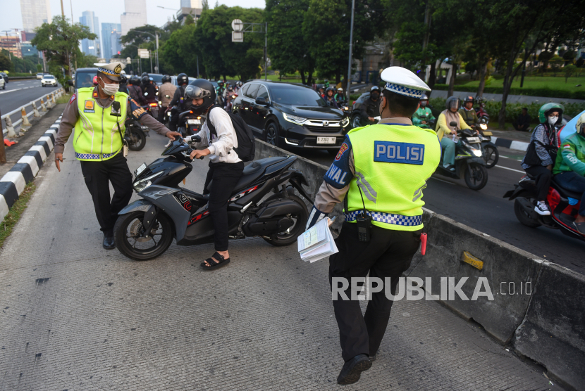 Polisi menilang pengendara yang menerobos jalur Bus TransJakarta di Jalan Gatot Subroto, Jakarta, Rabu (19/6/2024). Korlantas Polri dalam kurun awal tahun 2024 hingga 14 Mei 2024 telah menindak 564.838 pelanggar lalu lintas melalui sistem tilang manual dan tilang elektronik atau Electronic Traffic Law Enforcement (ETLE). 