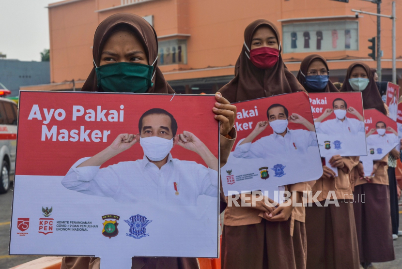 Sejumlah pelajar menyosialisasikan penggunaan masker di Jalan RE Martadinata, Cikarang, Kabupaten Bekasi.
