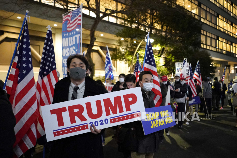  Orang-orang memegang plakat selama demonstrasi di Tokyo, Jepang, 6 Januari 2021. Ratusan orang menggelar unjuk rasa untuk menunjukkan dukungan mereka kepada Presiden Donald Trump ketika anggota parlemen AS akan mengkonfirmasi suara Electoral College yang dimenangkan oleh Joe Biden.