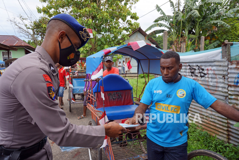 Anggota Polisi Air dan Udara (Polairud) membagikan masker kepada tukang becak di Pulau Dom Sorong Kepulauan, Kota Sorong, Papua Barat.
