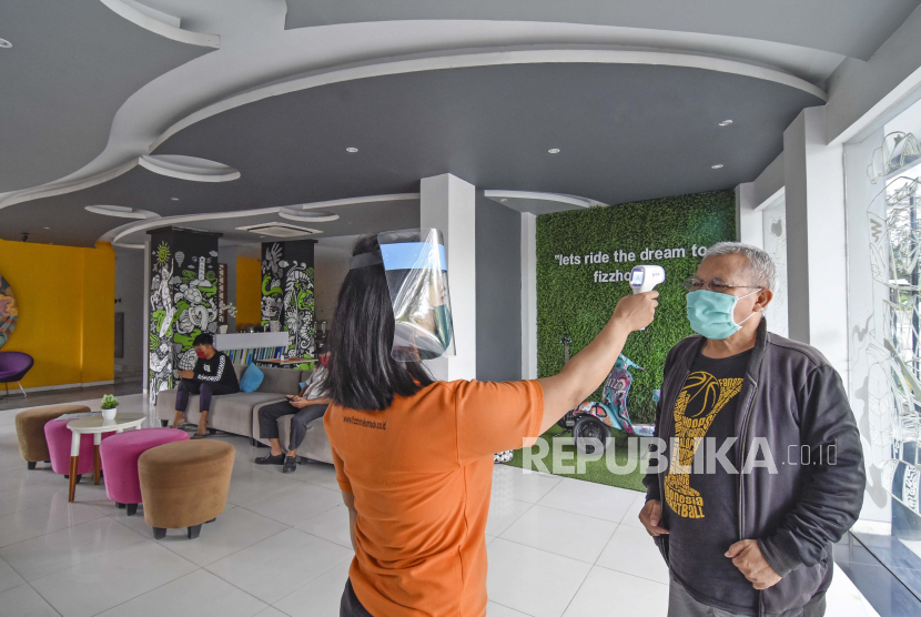 Ratusan karyawan hotel di Mataram dirumahkan akibat dampak Covid-19. Foto seorang petugas mengecek suhu tubuh pengunjung yang akan menginap di Fizz Hotel di Mataram, Lombok, NTB.