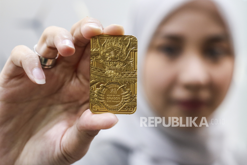 Petugas menunjukkan emas edisi Imlek berupa gambar Naga Kayu di Butik Emas Antam, Setia Budi, Jakarta, Jumat (2/2/2024). 