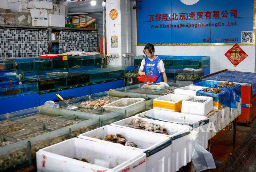 Seorang pedagang menyortir barang di pasar makanan laut di Beijing, Cina, 23 Agustus 2023.