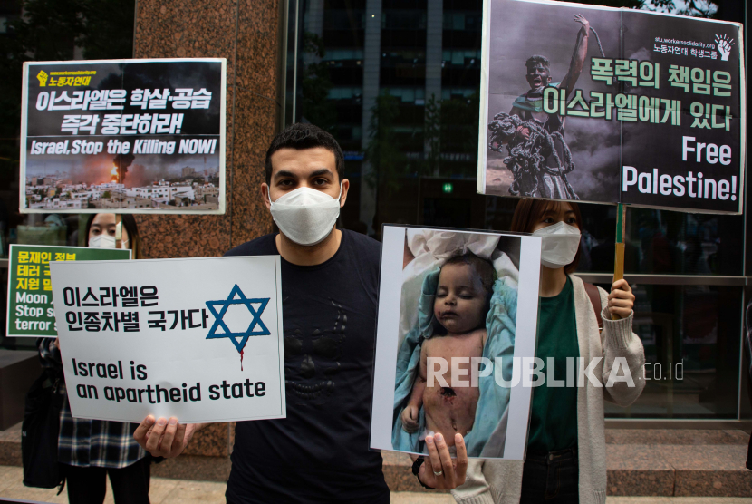 Para pengunjuk rasa memegang spanduk dan gambar selama unjuk rasa menentang serangan militer Israel di Jalur Gaza, di luar kedutaan Israel di Seoul, Korea Selatan, Selasa (18/5).