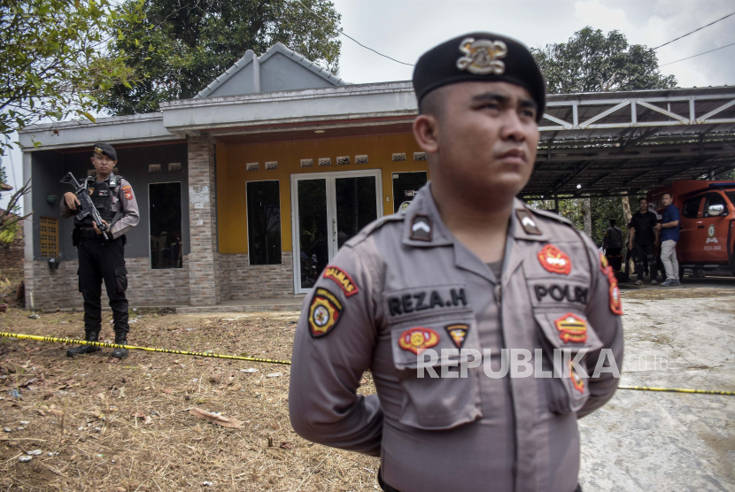Petugas kepolisian berjaga saat olah tempat kejadian perkara di area rumah korban di Jalancagak, Kabupaten Subang, Jawa Barat, Selasa (24/10/2023). Direktorat Reserse Kriminal Umum (Dirkrimum) Polda Jabar melakukan olah tempat kejadian perkara (TKP) ulang kasus pembunuhan  ibu dan anak, Tuti Suhartini  (55) dan Amalia Mustika Ratu (23) yang terjadi pada tahun 2021. Dalam kasus tersebut, Dirkrimum Polda Jabar menetapkan lima orang tersangka yaitu Yosep Hidayah, M Ramdanu, Mimin, Arighi Reksa Pratama dan Abi.