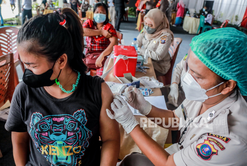 Reaksi seorang wanita saat petugas kesehatan menyuntikkan dosis vaksin Sinovac COVID-19 selama kampanye vaksinasi untuk vendor di pasar tradisional di Medan, Indonesia, 17 September 2021. 