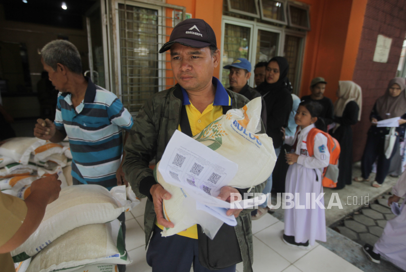 Warga membawa beras yang dibagikan saat penyaluran Bansos CBP di Kantor Kelurahan Mulyaharja, Kota Bogor, Jawa Barat, Senin (4/3/2024). Pemerintah terus mengupayakan membantu masyarakat mendapatkan barang kebutuhan pokok terutama beras yang mengalami kenaikan harga melalui program Bulog Siaga dan penyaluran Bantuan Sosial Cadangan Beras Pemerintah (Bansos CBP) untuk memenuhi kebutuhan pangan rumah tangga masyarakat. Bulog Siaga menyediakan kebutuhan pokok berupa beras SPHP dua ton, beras premium 500 kilogram, gula pasir 100 kilogram, minyak goreng 120 liter dan tepung beras 24 kilogram yang dijual untuk masyarakat dengan harga yang lebih murah di pasaran. Sedangkan, Bansos CBP berupa beras yang dibagikan secara gratis diperuntukan bagi masyarakat di 12 RW Kelurahan Mulyaharja yang membutuhkan.