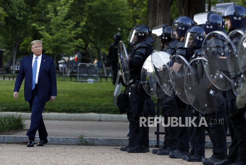 Presiden Donald Trump berjalan melewati polisi di Lafayette Park setelah mengunjungi bagian luar Gereja St. John di seberang Gedung Putih, Washington, Amerika Serikat,  Senin (1/6). Mantan Menhan AS Jim Mattis menuduh Trump memecah belah Amerika.