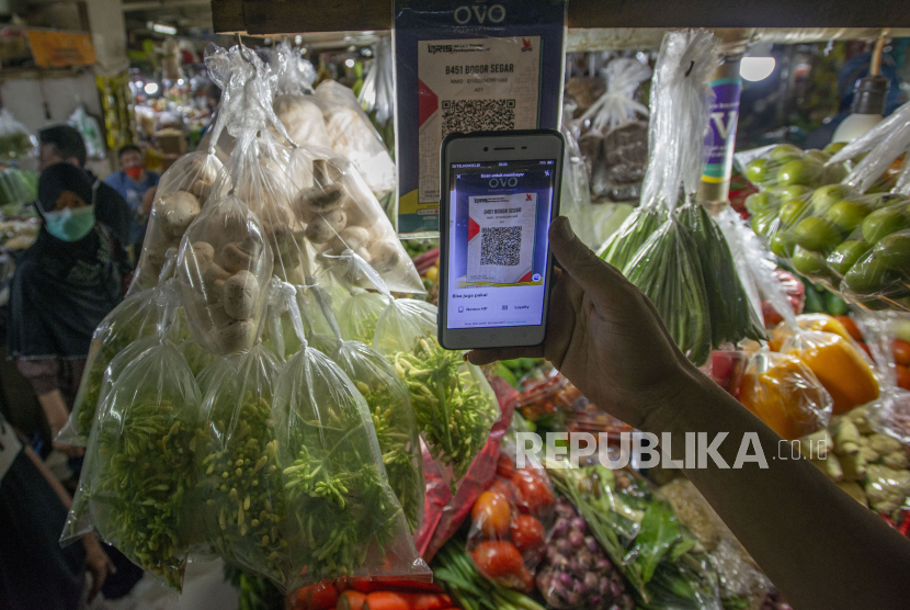 Warga memindai kode batang untuk pembayaran non tunai di salah satu los sembako di Pasar Mayestik, Kebayoran Baru, Jakarta, Selasa (11/5/2021). Pemerintah akan menaikkan PPN dari 10 persen menjadi 11 persen.