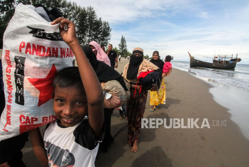 Sejumlah etnis Rohingya berjalan menunju tempat istirahat setelah dievakuasi warga di Desa Bluka Teubai, Kecamatan Dewantara, Aceh Utara, Aceh, Rabu (16/11/2022). 