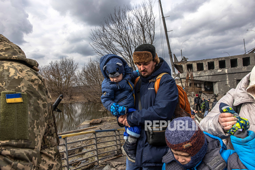  Orang-orang dengan anak-anak menyeberangi jembatan yang hancur saat mereka melarikan diri dari kota garis depan Irpin, wilayah Kyiv (Kiev), Ukraina, 07 Maret 2022. Irpin, kota yang terletak di dekat kota Kyiv mengalami pertempuran sengit selama hampir seminggu antara Ukraina dan Rusia militer memaksa ribuan orang untuk melarikan diri dari kota.