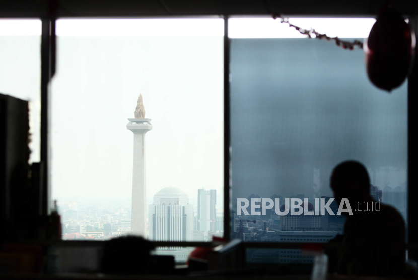 Aparatur sipil negara (ASN) saat bekerja dengan latar belakang Tugu Monas di kompleks Balai Kota DKI Jakarta, Senin (21/8/2023). 