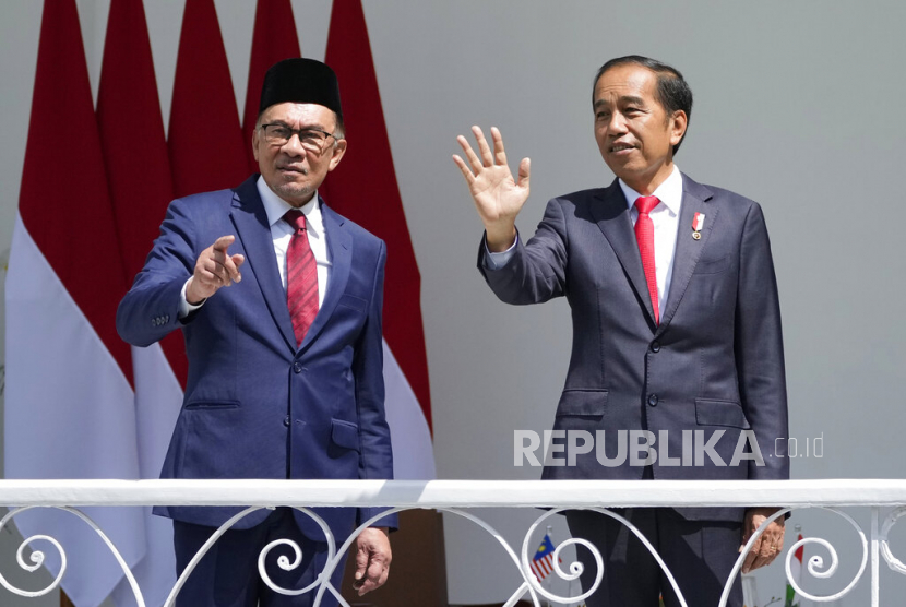 Presiden Joko Widodo (kanan) dan Perdana Menteri Malaysia Anwar Ibrahim melambaikan tangan kepada wartawan saat bertemu di istana kepresidenan di Bogor, Jawa Barat, Indonesia, Senin (9/1/2023).