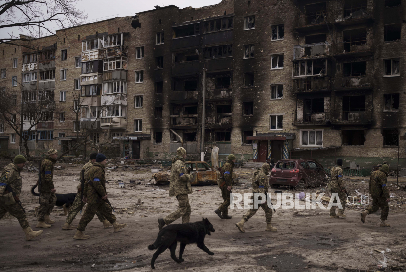 Tentara Ukraina berjalan di samping bangunan tempat tinggal yang rusak berat di Irpin, di pinggiran Kyiv, Ukraina, Rabu, 6 April 2022.