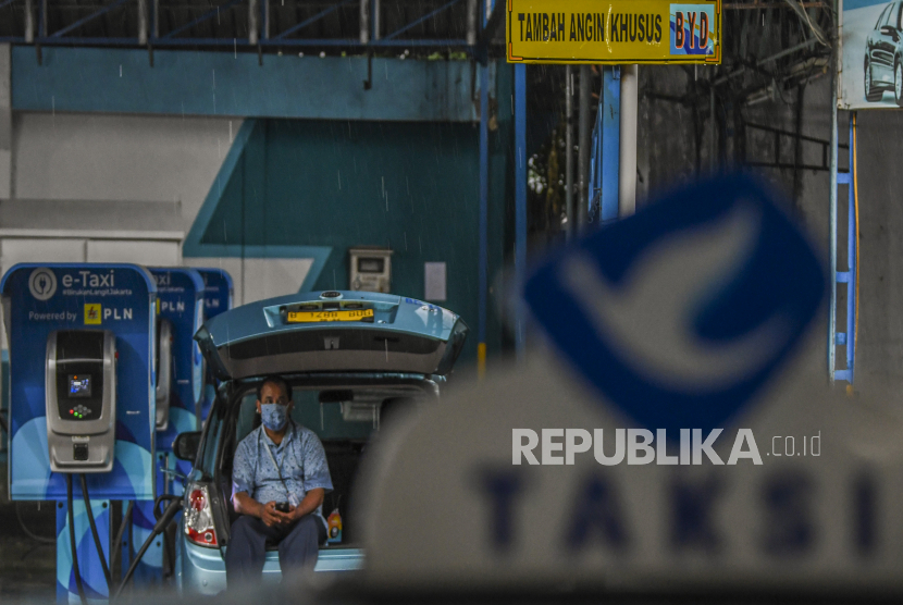 Pengemudi menunggu pengisian daya mobil taksi listrik Bluebird (e-Taxi) di Kantor Pusat Bluebird Group, Mampang Prapatan,  Jakarta, Rabu (13/7/2022). 