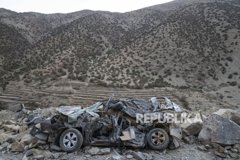 Sebuah mobil rusak berat akibat gempa tertinggal di pinggir jalan menuju desa Ijjoukak, dekat Marrakesh, Maroko, (9/9/2023).