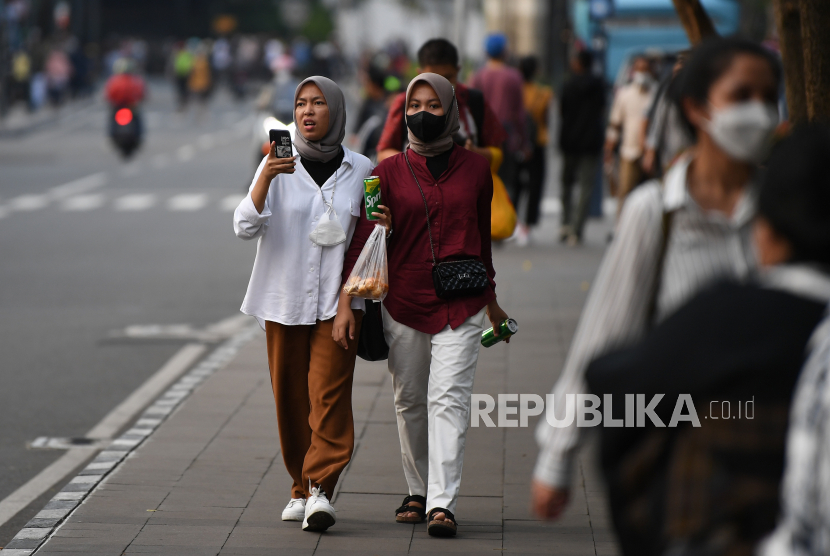 Warga berjalan di kawasan Stasiun MRT Dukuh Atas di Jakarta.