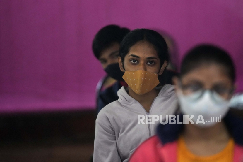 Remaja India menunggu untuk menerima vaksinasi mereka untuk COVID-19 di sebuah sekolah negeri, di New Delhi, India, Senin, 3 Januari 2022. 